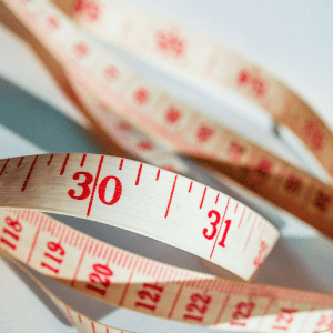 Close up of a white measuring tape with red measure marks